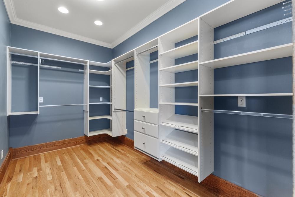 white custom shelving with blue painted walls and brown hardwood flooring