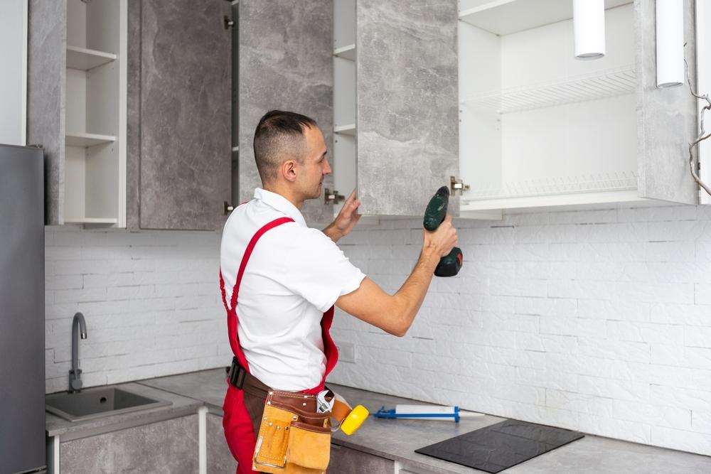 contractor installing cabinets in new remodeled kitchen