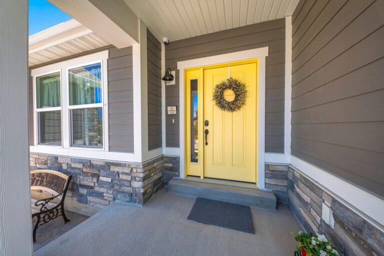 Yellow front door with wreath and sidelight at the entrance of a house