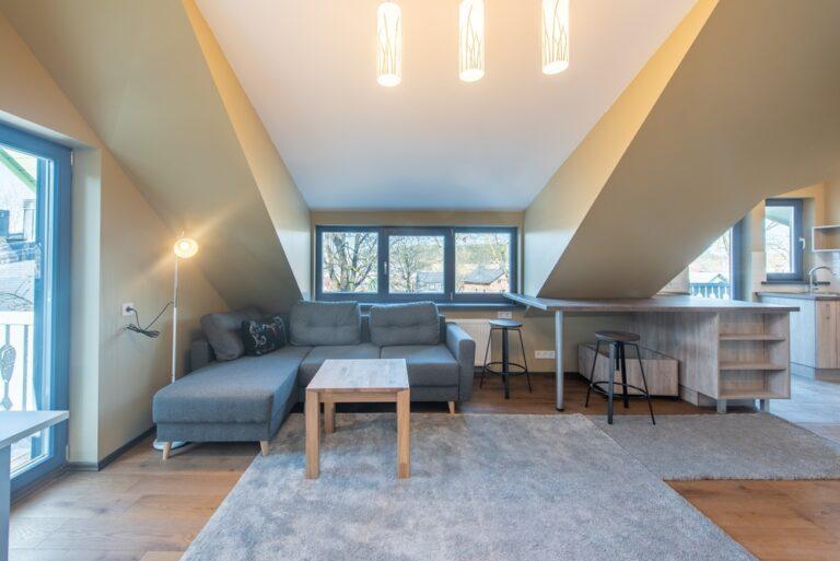 Cozy home attic with couches, countertops, and lights