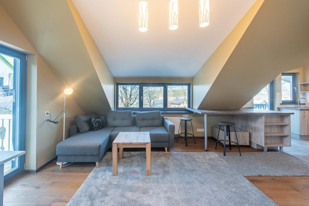 Cozy home attic with couches, countertops, and lights