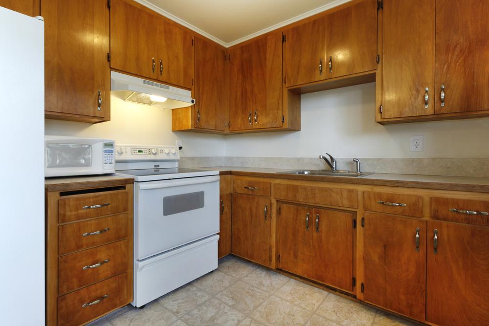 Old kitchen with wooden cabinets and outdated appliances